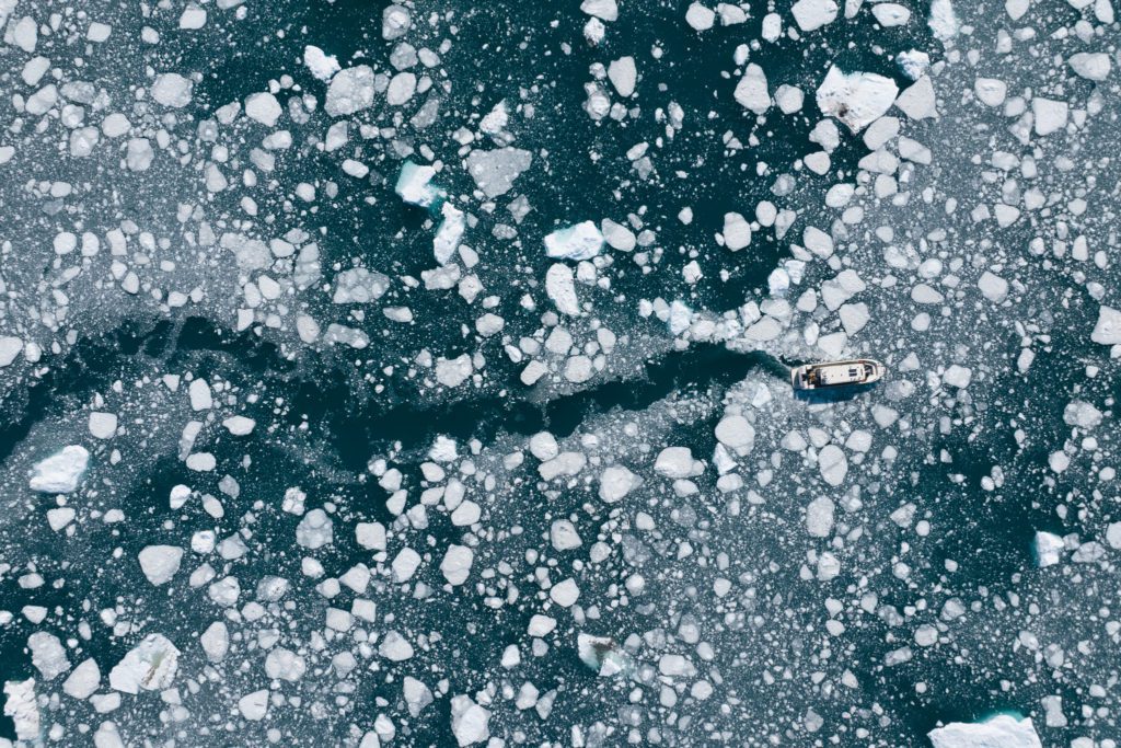 A boat sailing through ice near the Eqi glacier in West Greenland.