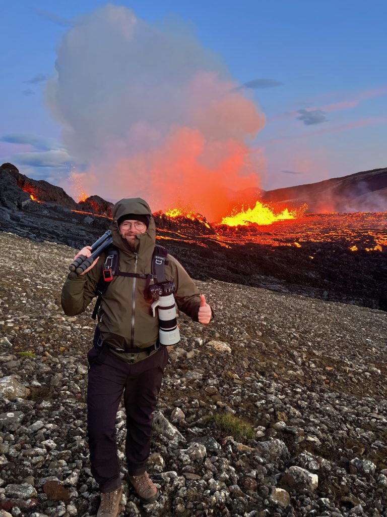 A photographer in front of the Meradalir volcanic eruption at the Fagradalsfjall volcano in Iceland.