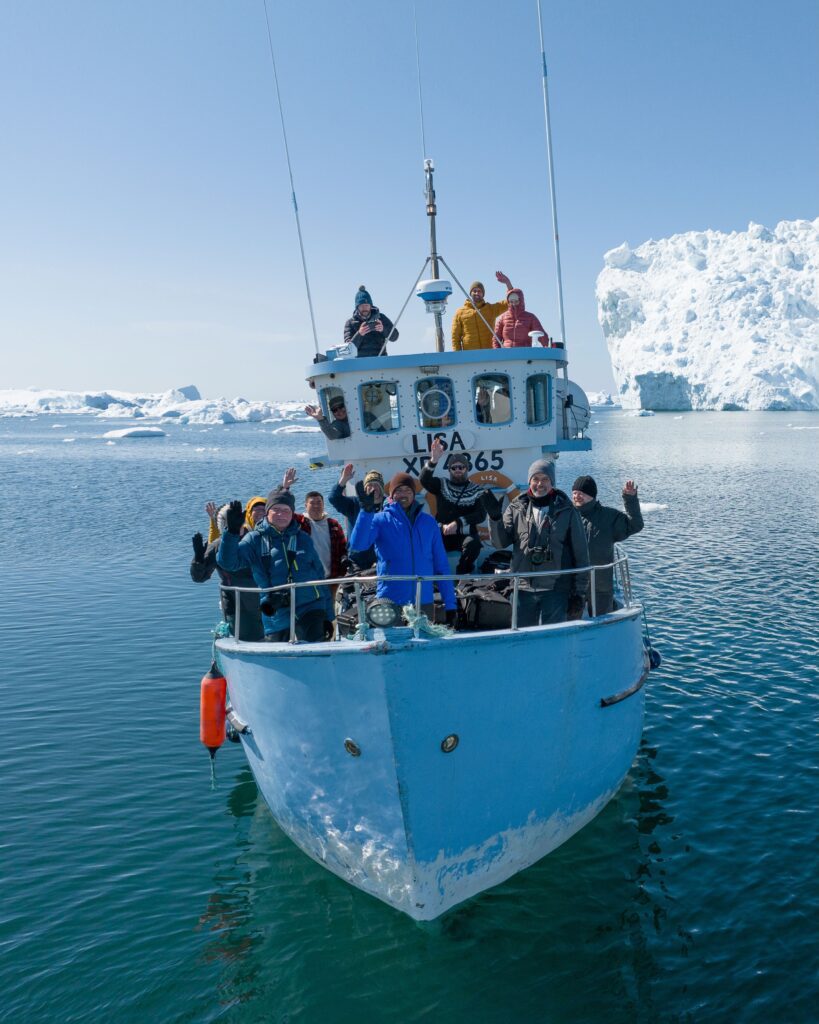 A group photo on the boat in Greenland during a photo tour