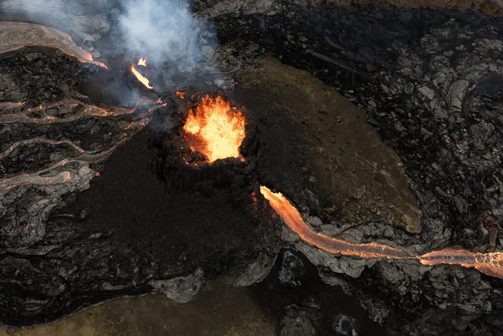 Top-down view of a Fagradalsfjall lava vent fountaining inside the crater with lava rivers spilling out.