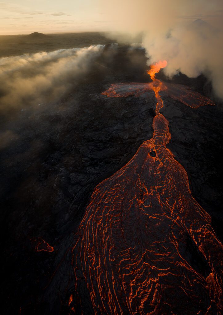 Sunset aerial of a long lava tongue stretching from a smoking fissure, Fagradalsfjall.