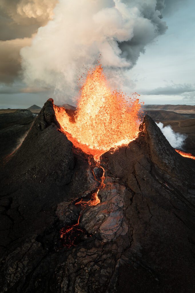 Aerial of a tall vertical lava fountain inside the Fagradalsfjall crater, Reykjanes Peninsula.