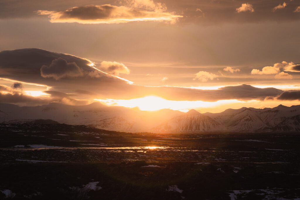 Sunset breaking through layered cloud over Hafnarfjall, viewed from Hraundalur in west Iceland.