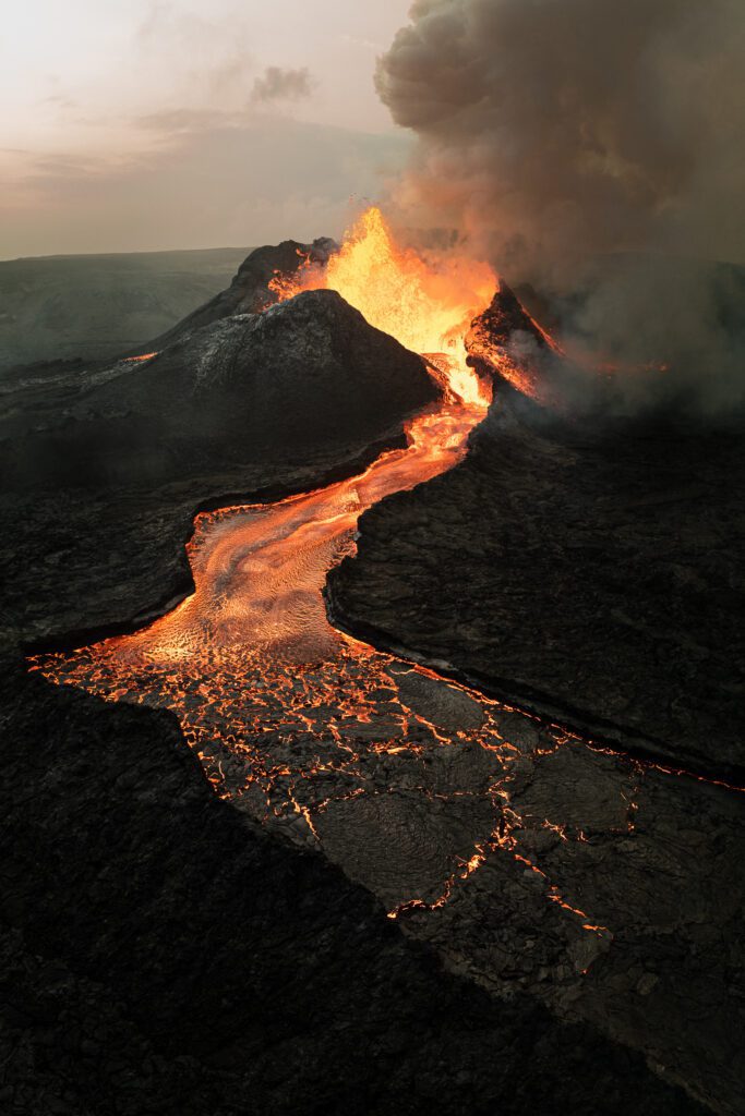 Cinder cone with a lava fountain and a glowing river flowing toward the camera.