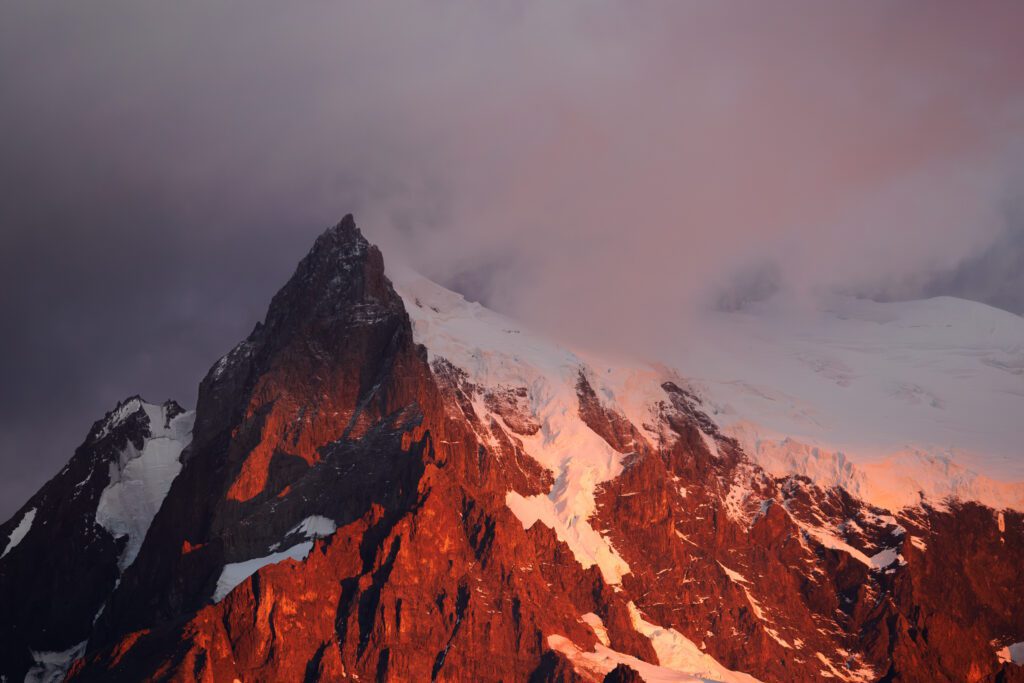 First-light alpenglow on a Torres del Paine peak with glacier behind, Patagonia.