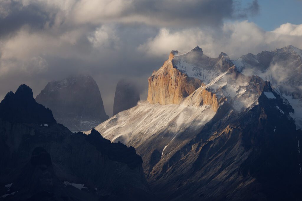 Telephoto view of Los Cuernos del Paine with snow blowing off the granite ridges.
