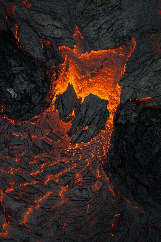 Top-down close-up of a glowing lava window in dark cooled crust.