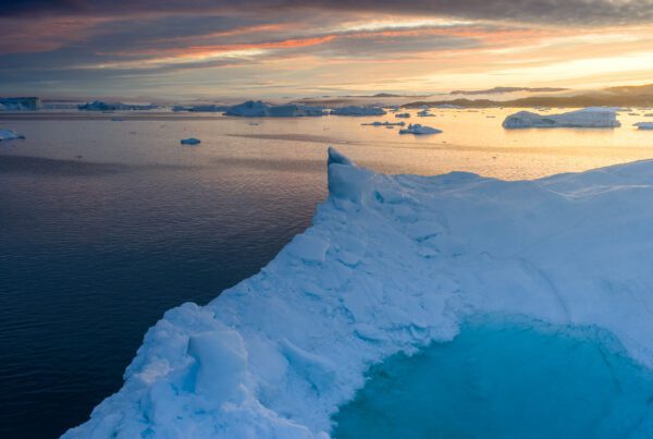 Iceberg edge at sunrise above the ice-filled waters of Disko Bay, Greenland.