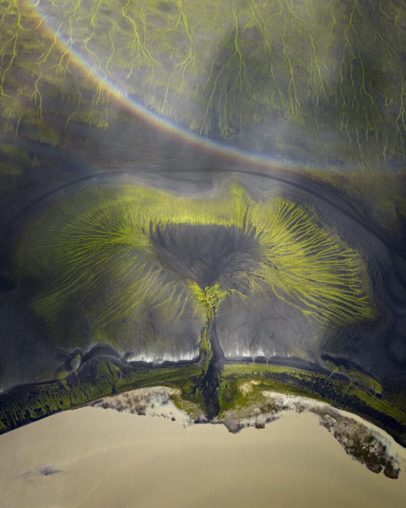 Mælifell cone silhouetted under a double rainbow on a dark Icelandic Highlands plain.