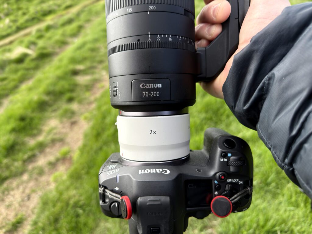 Top-down view of the RF 70-200mm F2.8 Z with the RF 2x extender on a Canon EOS R5, held over grass